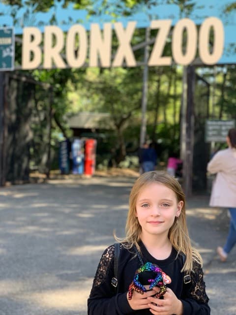 Penelope foran skiltet til Bronx Zoo i New York