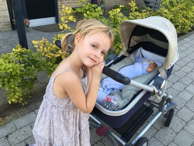 Penelope ved siden af en barnevogn i solen